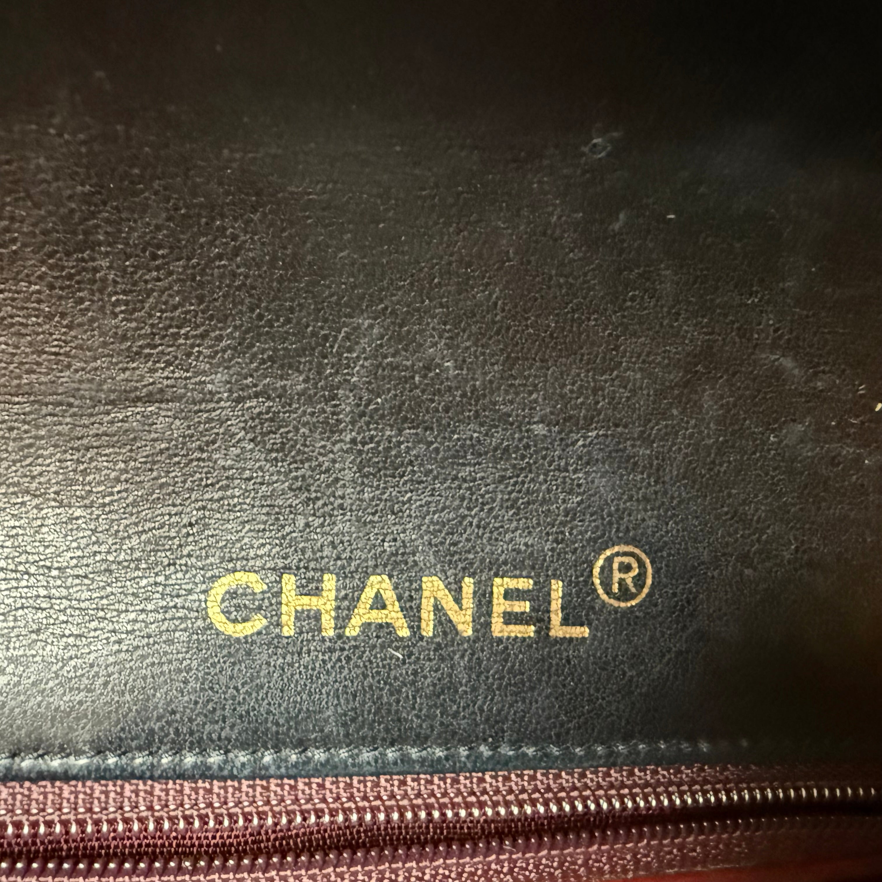 Close-up of a Chanel logo on a black leather authentic single full flap classic flap vintage